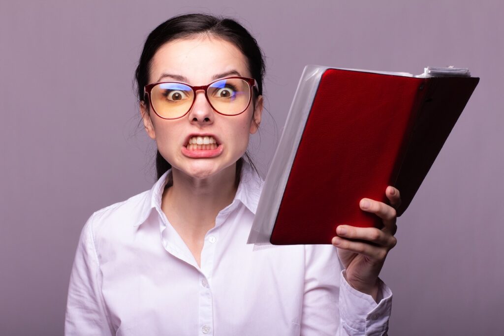 Grimacing woman holding red book